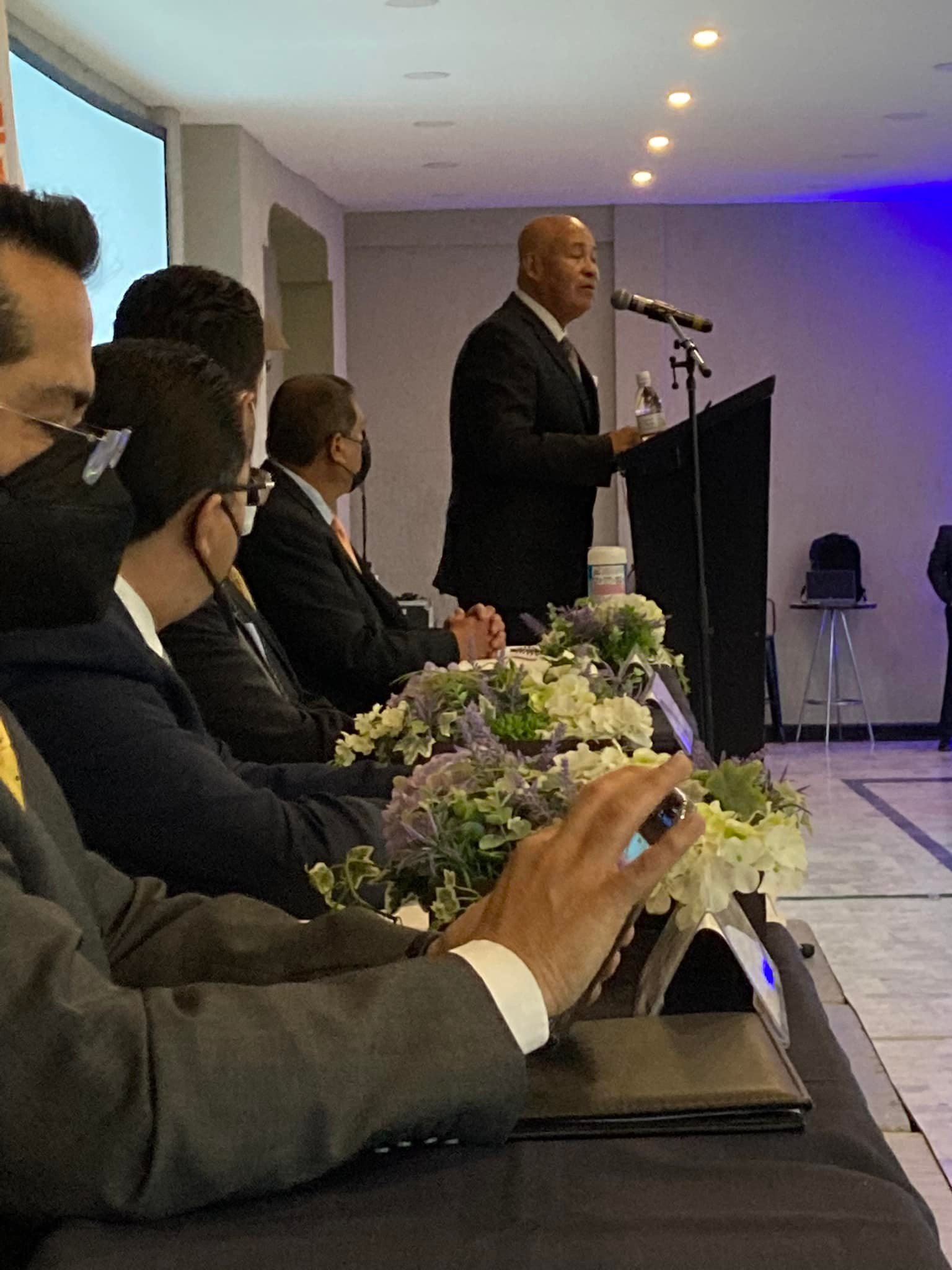 Manuel Ríos Zúñiga dirigiéndose a un panel desde el pódium